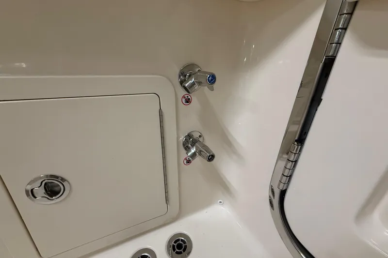 Slide: The Image of 2026 Grady-White Canyon 306 boat interior with faucet and storage compartment. - 37