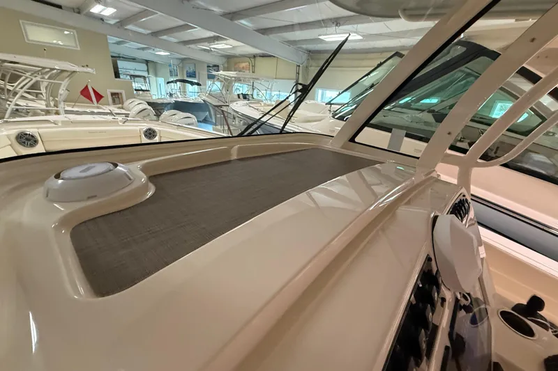 Slide: The Image of 2026 Grady-White Canyon 326 boat interior, showcasing dashboard and seating area in showroom. - 12
