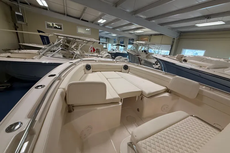 Slide: The Image of 2026 Grady-White Canyon 326 boat interior in showroom, featuring luxurious seating and modern design. - 16