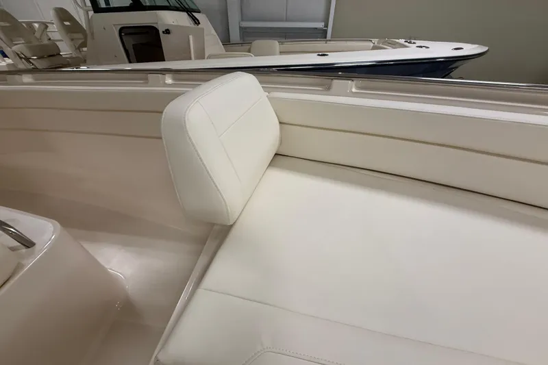 Slide: The Image of 2026 Grady-White Canyon 326 boat interior with white cushioned seating. - 18