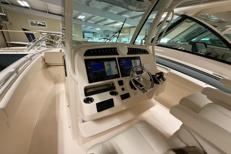 Slide: The Image of 2026 Grady-White Canyon 326 boat cockpit with modern navigation system and steering wheel. - 9
