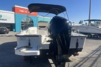 Slide: The Image of 2024 Boston Whaler 210 Montauk boat with outboard motor, parked outdoors. - 5