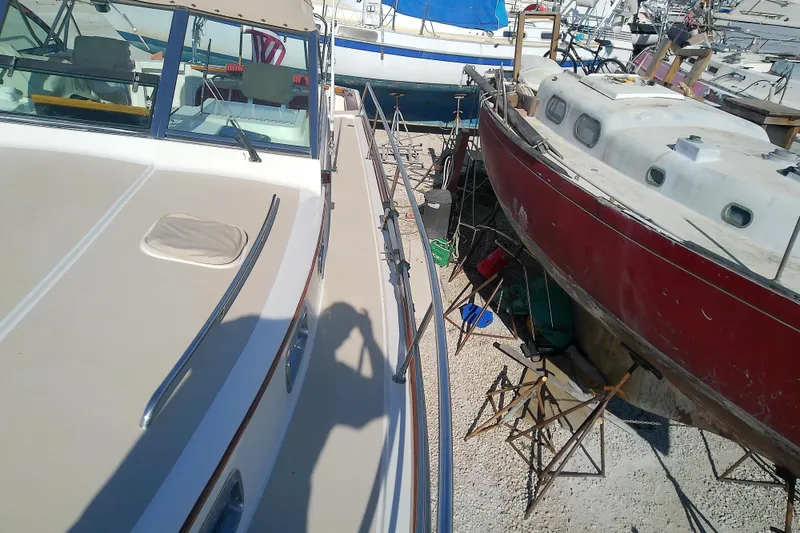 Slide: The Image of 2002 Sabreline 36 Express boat docked beside a red sailboat in a marina. - 18