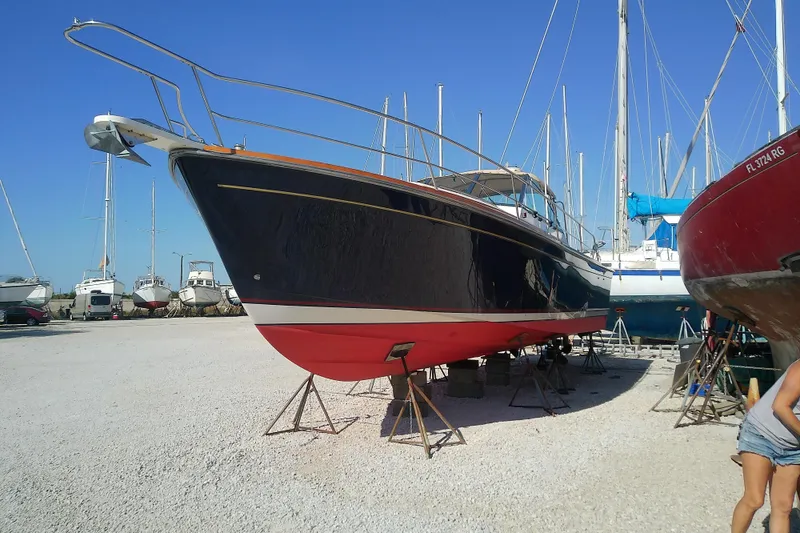 Slide: The Image of 2002 Sabreline 36 Express boat on stands in a marina, clear blue sky. - 2
