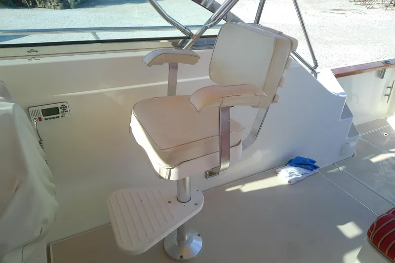 Slide: The Image of Captain's chair on 2002 Sabreline 36 Express boat, featuring white upholstery and footrest. - 24