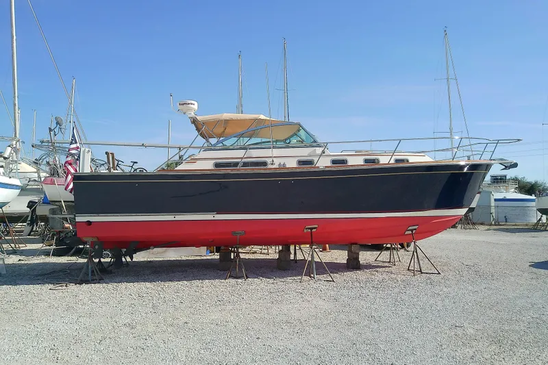Slide: The Image of 2002 Sabreline 36 Express boat on stands in a marina, clear blue sky. - 38