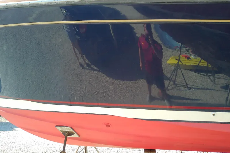 Slide: The Image of 2002 Sabreline 36 Express boat hull with reflection, featuring red and blue colors. - 4