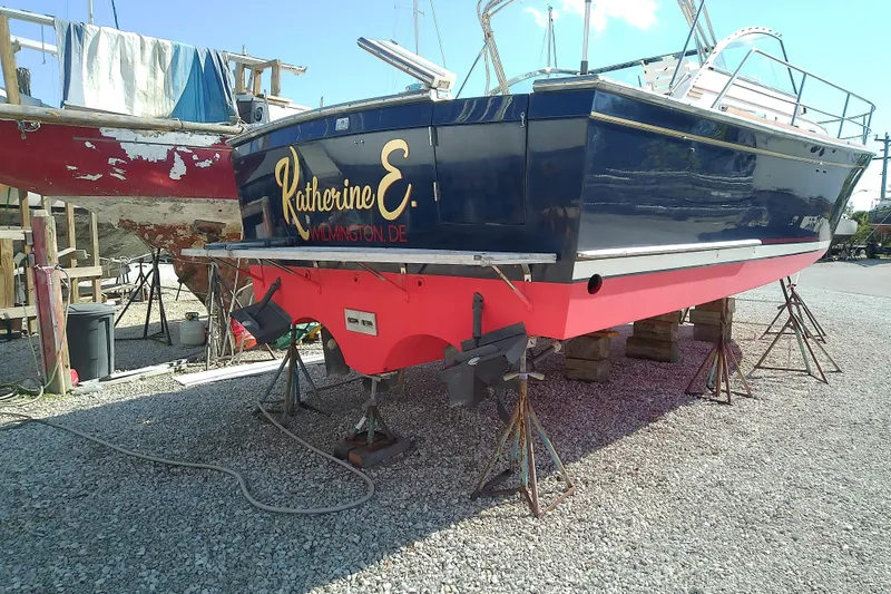 Slide: The Image of 2002 Sabreline 36 Express boat on stands, named "Katherine E." in a boatyard. - 43
