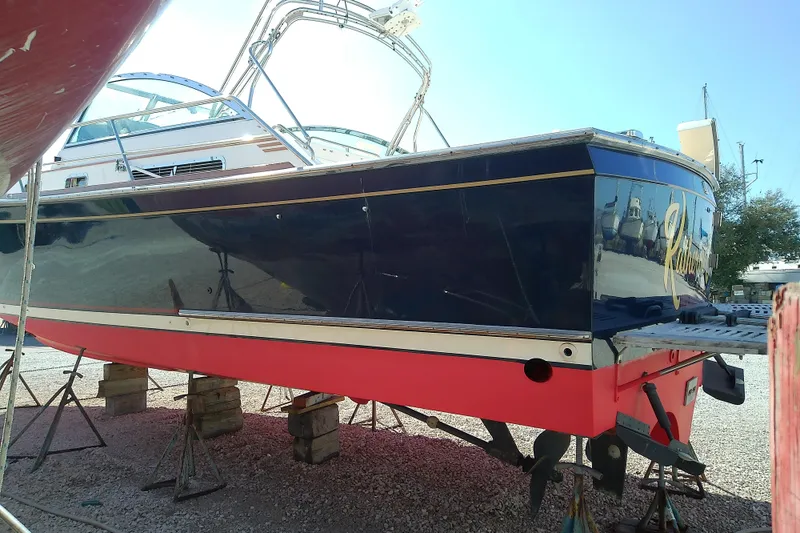 Slide: The Image of 2002 Sabreline 36 Express boat on stands, blue hull with red bottom, outdoor setting. - 48