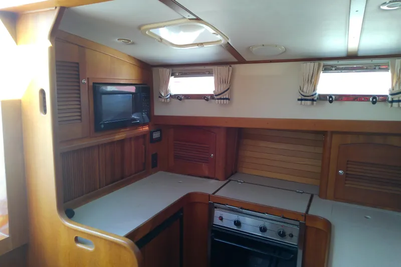 Slide: The Image of Interior of 2002 Sabreline 36 Express yacht kitchen with wood cabinetry and appliances. - 54