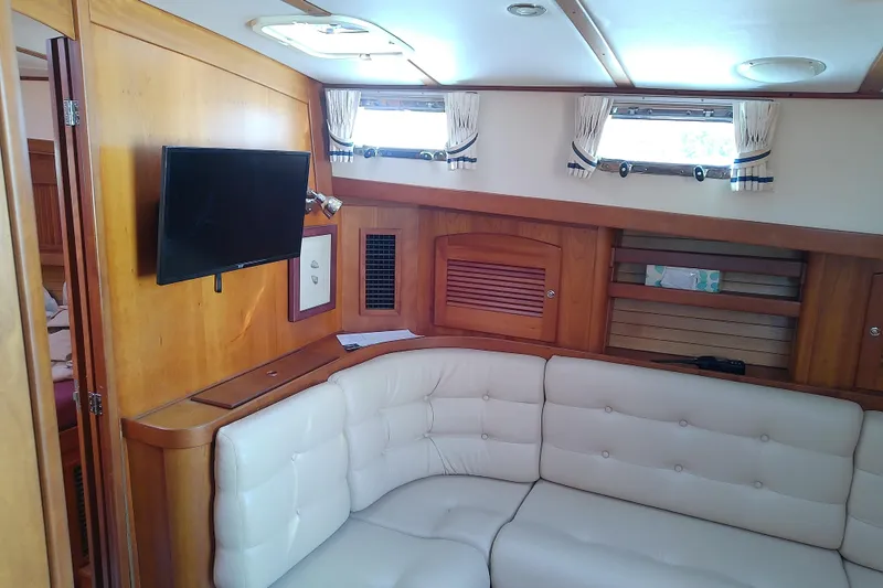 Slide: The Image of Interior of 2002 Sabreline 36 Express yacht with white seating and mounted TV. - 57