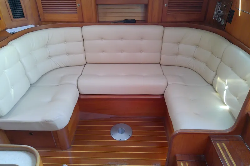 Slide: The Image of Luxurious seating area on 2002 Sabreline 36 Express yacht with cream cushions and wooden accents. - 58