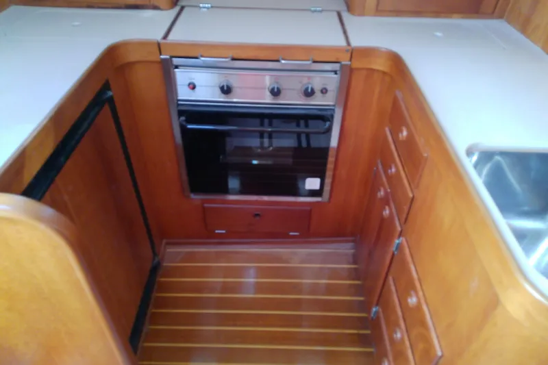 Slide: The Image of 2002 Sabreline 36 Express yacht kitchen with wooden cabinetry and built-in oven. - 60