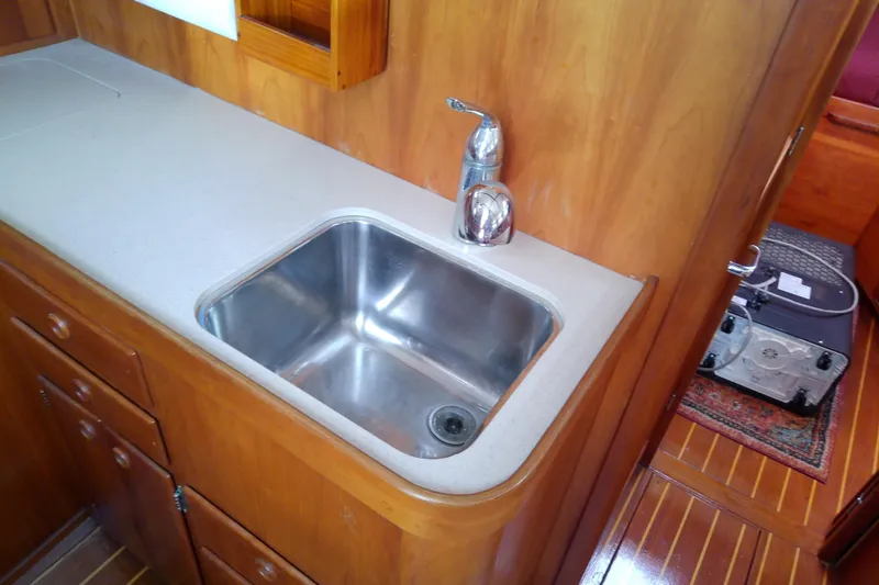 Slide: The Image of 2002 Sabreline 36 Express yacht interior with wooden cabinetry and stainless steel sink. - 66