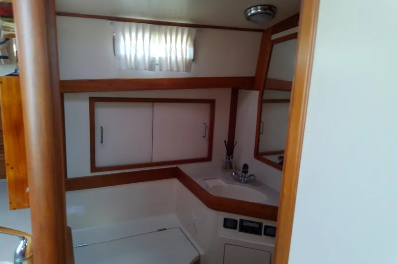 Slide: The Image of 2002 Sabreline 36 Express yacht bathroom with sink, mirror, and storage cabinets. - 78