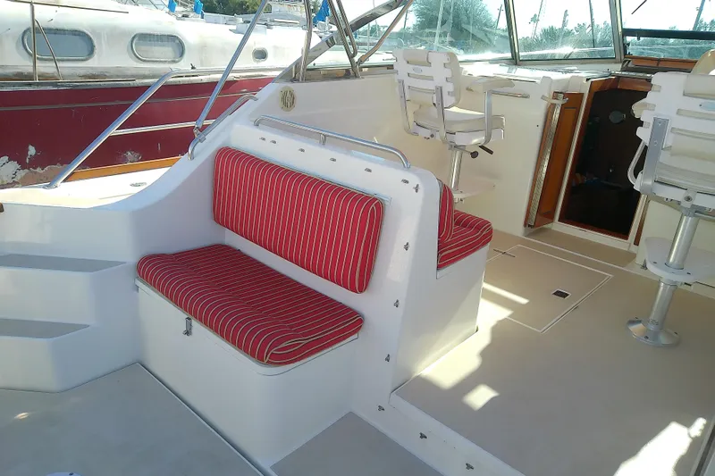 Slide: The Image of 2002 Sabreline 36 Express boat interior with red-striped seating and helm chairs. - 11