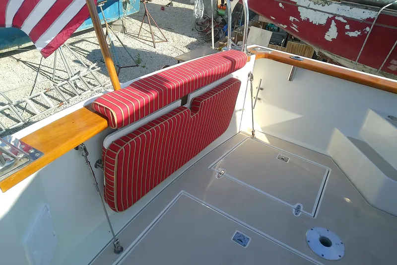 Slide: The Image of 2002 Sabreline 36 Express boat interior with striped red cushions and wooden accents. - 12