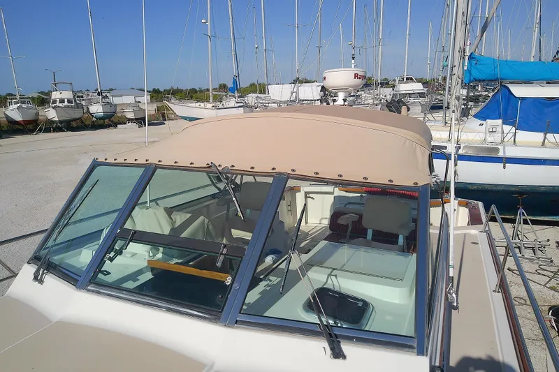 Slide: The Image of 2002 Sabreline 36 Express boat with beige canopy in a marina setting. - 19