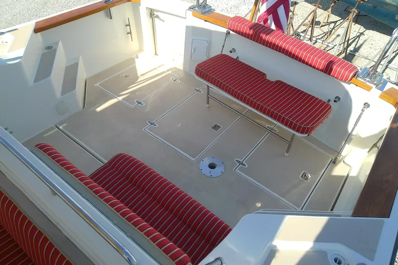 Slide: The Image of 2002 Sabreline 36 Express boat interior with red-striped seating and spacious deck. - 20