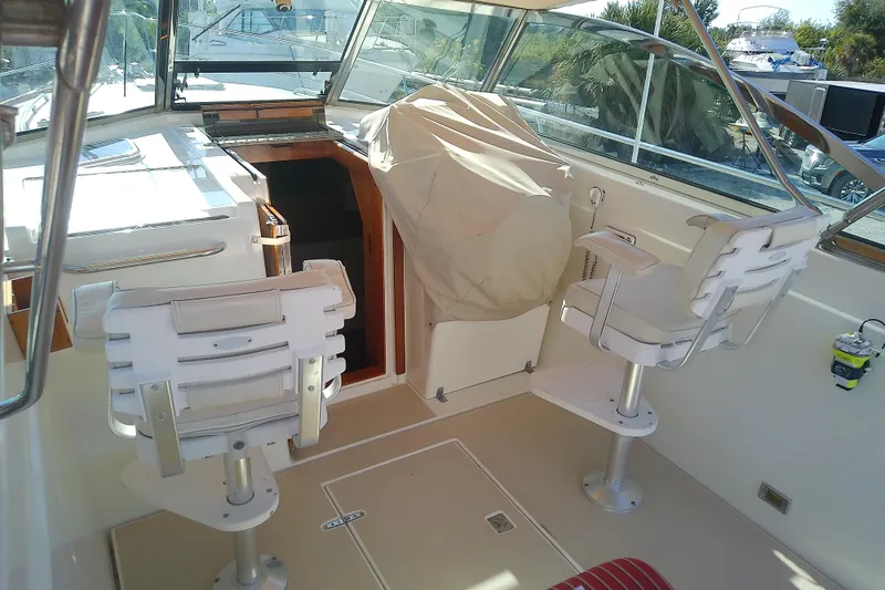 Slide: The Image of 2002 Sabreline 36 Express boat interior with helm chairs and covered console. - 21