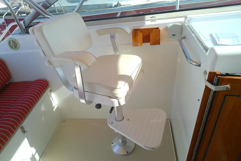Slide: The Image of Captain's chair on 2002 Sabreline 36 Express boat, featuring white upholstery and footrest. - 25