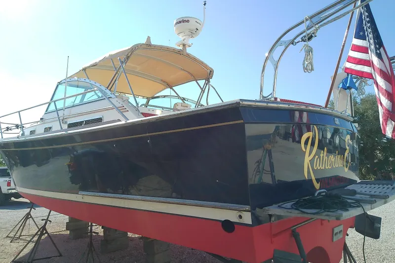 Slide: The Image of 2002 Sabreline 36 Express boat with American flag, docked on land. - 3