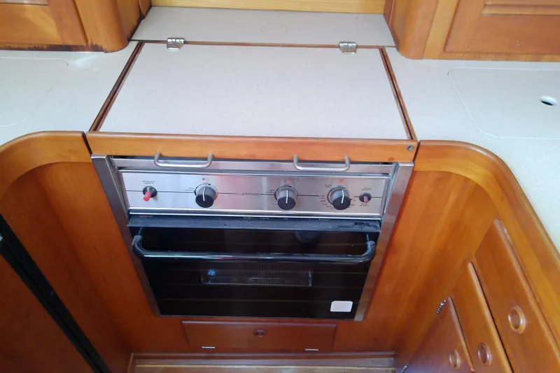 Slide: The Image of 2002 Sabreline 36 Express yacht kitchen with built-in oven and wooden cabinetry. - 62