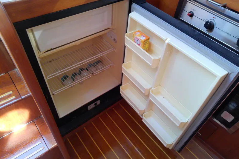 Slide: The Image of Open refrigerator in 2002 Sabreline 36 Express boat galley, showing shelves and baking soda box. - 65