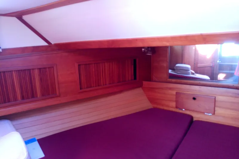 Slide: The Image of 2002 Sabreline 36 Express cabin interior with wooden paneling and maroon bedding. - 68