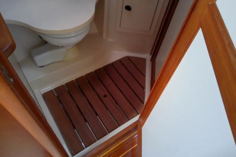 Slide: The Image of 2002 Sabreline 36 Express boat bathroom with wooden flooring and compact toilet. - 79