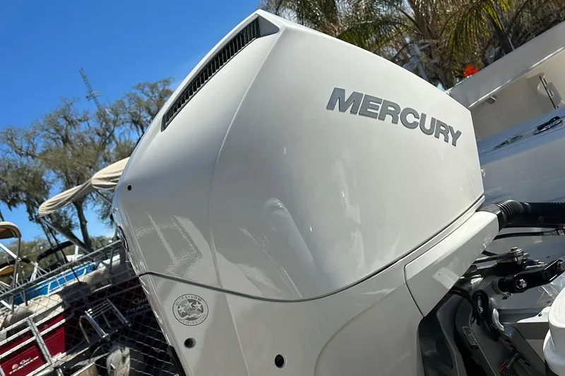 Slide: The Image of 2026 Bayliner Trophy T22CC with Mercury outboard engine, sunny day, palm trees in background. - 15
