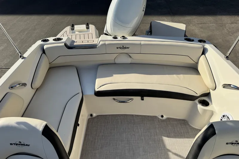 Slide: The Image of 2022 Stingray 191 DC boat interior with beige seating and cup holders. - 12