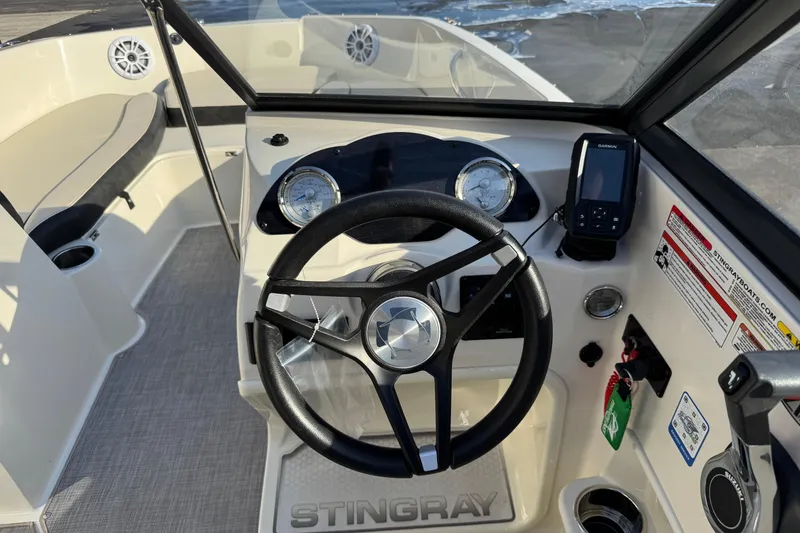 Slide: The Image of 2022 Stingray 191 DC boat dashboard with steering wheel and navigation system. - 13