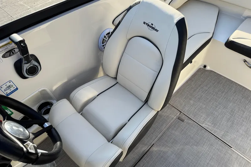 Slide: The Image of 2022 Stingray 191 DC boat interior with white cushioned seating and steering wheel. - 16