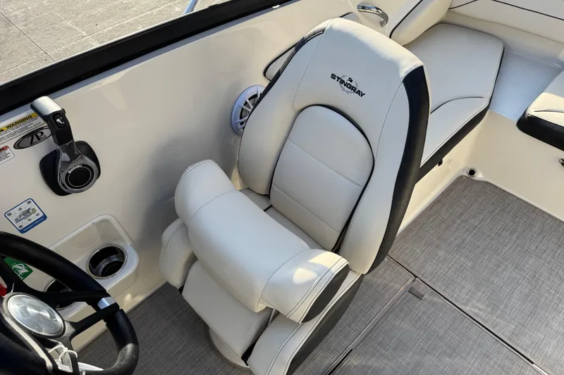Slide: The Image of 2022 Stingray 191 DC boat interior with white and black seating and control panel. - 17