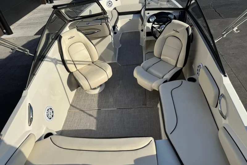 Slide: The Image of 2022 Stingray 191 DC boat interior with beige seating and modern dashboard. - 19