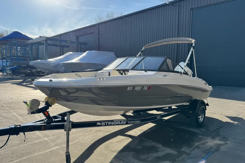 Slide: The Image of 2022 Stingray 191 DC boat on trailer in outdoor storage area. - 2