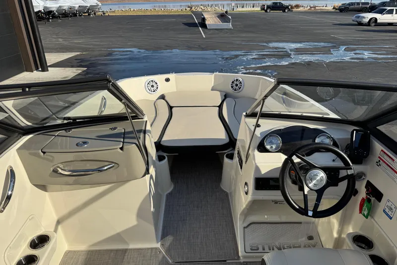 Slide: The Image of 2022 Stingray 191 DC boat interior with steering wheel, seating, and dashboard controls. - 23