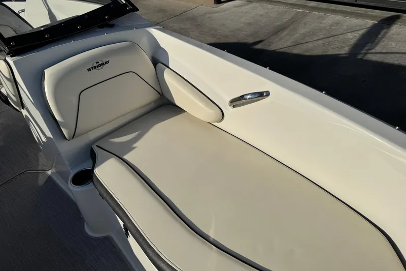 Slide: The Image of 2022 Stingray 191 DC boat interior with beige seating and cup holder. - 8