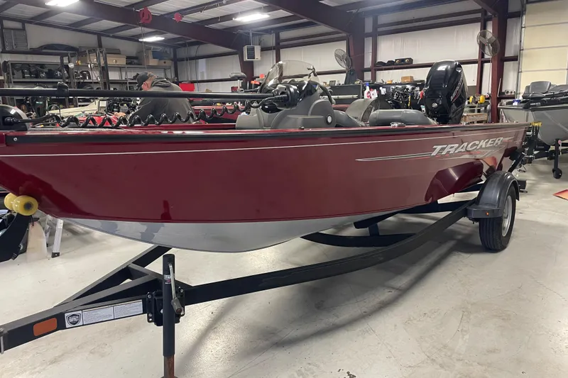 Slide: The Image of 2021 Tracker Pro Guide V-16 SC boat in a showroom, red exterior. - 4