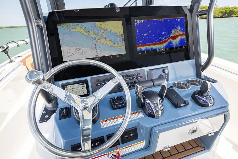 Slide: The Image of Manufacturer Provided Image: 2025 Cobia 265 Center Console Open boat dashboard with navigation screens and controls. - 14