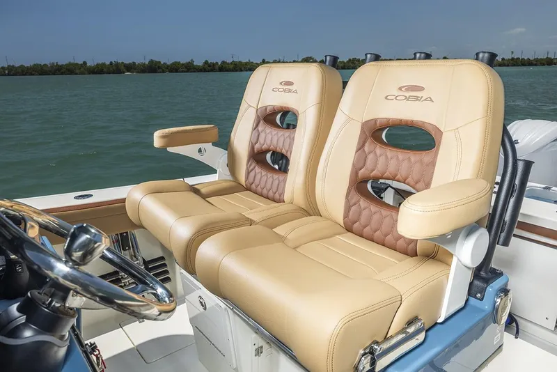 Slide: The Image of Manufacturer Provided Image: 2025 Cobia 265 Center Console Open boat seats, tan leather, on calm water. - 15
