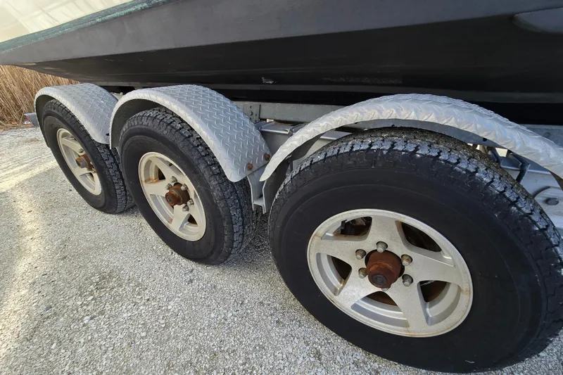 Slide: The Image of Triple-axle trailer for 2006 Albemarle 268 Express Fisherman boat on gravel surface. - 17