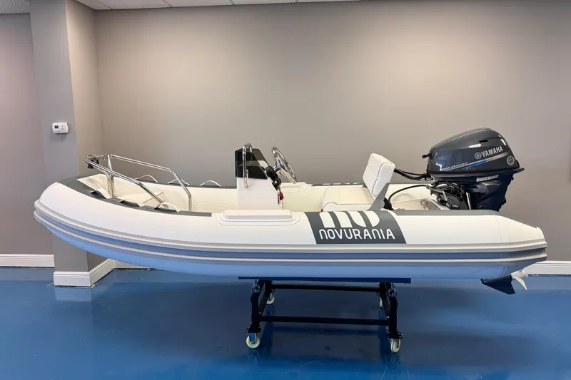 Slide: The Image of 2025 Novurania DL 335 boat with Yamaha 25 HP engine displayed indoors. - 1