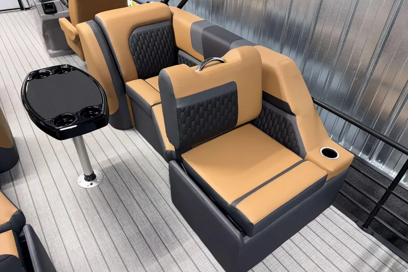 Slide: The Image of 2026 Sylvan L3 LZ boat interior with tan and gray seating, black table, and cup holders. - 20