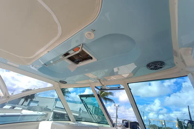 Slide: The Image of Interior view of 2026 Grady-White Freedom 325 boat with blue ceiling and speakers. - 16