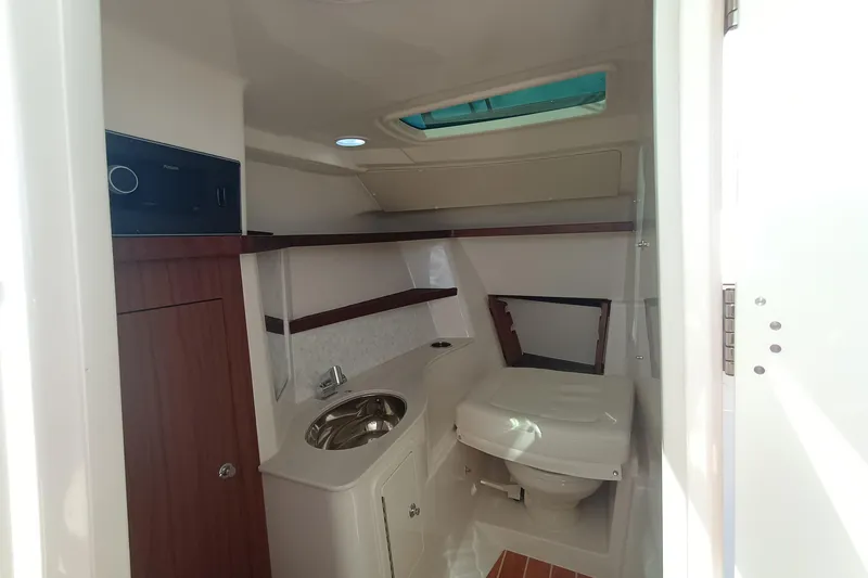 Slide: The Image of 2026 Grady-White Freedom 325 boat interior with compact bathroom and sink. - 21