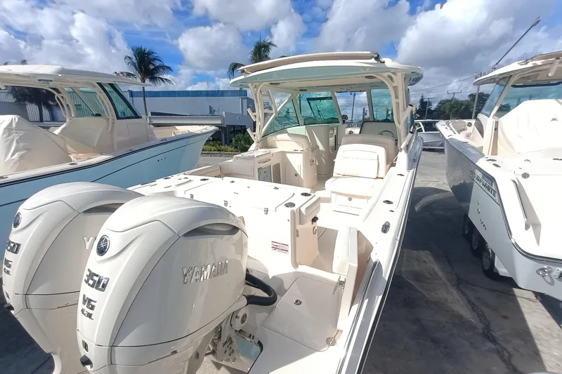 Slide: The Image of 2026 Grady-White Freedom 325 boat with dual Yamaha engines, docked under a blue sky. - 30
