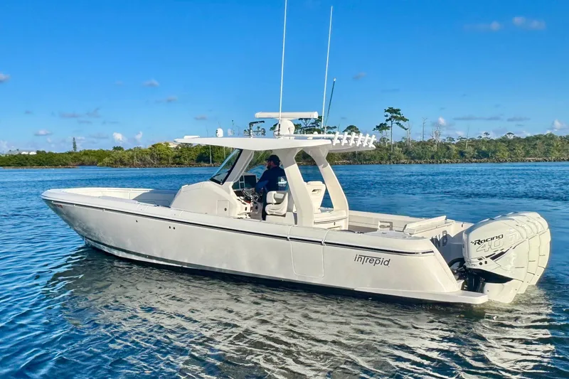 The Image of 2020 Intrepid 375 Nomad SE boat on calm water under clear blue sky. - 0