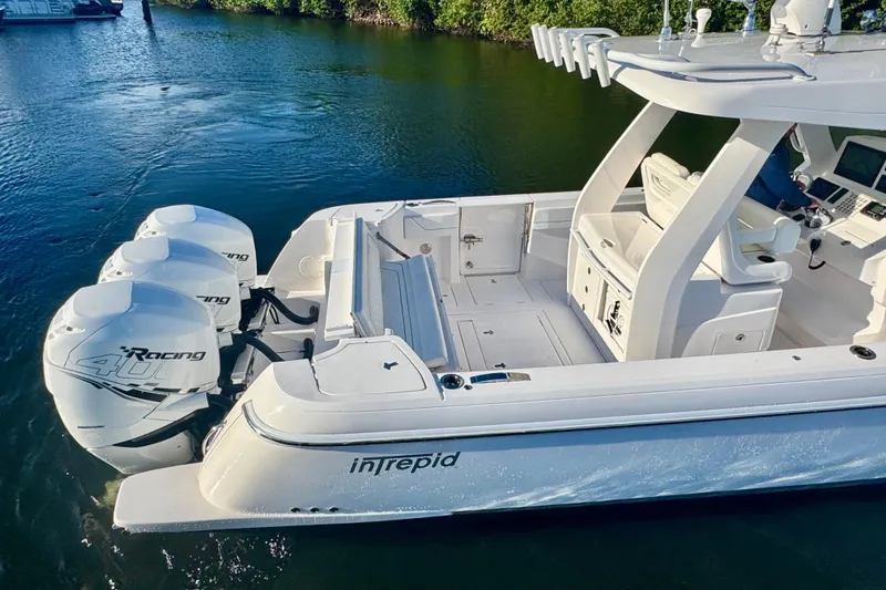 Slide: The Image of 2020 Intrepid 375 Nomad SE boat with triple outboard engines on calm water. - 11